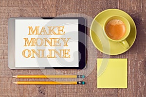 Make money online concept with digital tablet and coffee cup. View from above