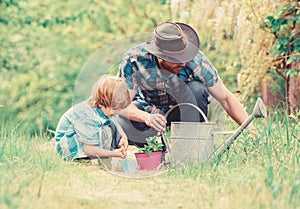 Make planet greener. Growing plants. Take care of plants. Day of earth. Boy and father in nature. Gardening tools