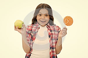Make right choice. Can sugar sweet taste make us happy. Girl holds sweet lollipop and apple. School lunch alternative