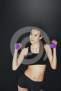 Make sure you progress. a young woman working out with dumbbells.