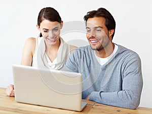 They make a terrific team. A handsome man and a beautiful young woman working together on a laptop.