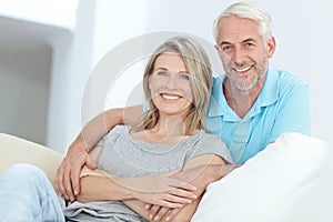 We make time to relax together at home. Portrait of a happy mature couple relaxing at home.