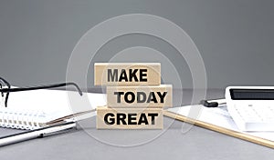 MAKE TODAY GREAT text on wooden block with notebook,chart and calculator, grey background