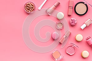 Make-up accessories, fashion stylish cosmetics and macaroon on pink desk background top view copy space