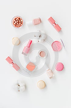 Make-up accessories, fashion stylish cosmetics and macaroon on white desk background top view