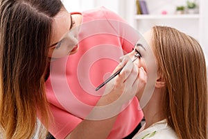 Make-up artist apply eye shadow with brush, beauty