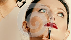 Make-up artist applying Angelina Joli style make-up on model`s face