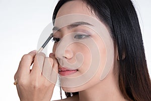 Make-up artist applying brown color eyeshadow make up on model& x27;s