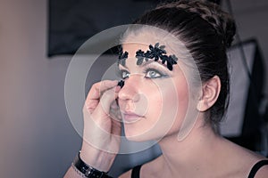 Make-up Artist is Applying a Decorative Black Lace on Female Model`s Face