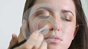 Make-up artist applying eyelash makeup to model`s eye. Close up view