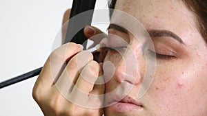 Make-up artist applying eyelash makeup to model`s eye. Close up view