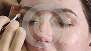 Make-up artist applying eyelash makeup to model`s eye. Close up view