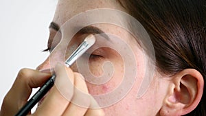 Make-up artist applying eyelash makeup to model`s eye. Close up view