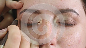 Make-up artist applying eyelash makeup to model`s eye. Close up view