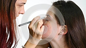 Make-up artist applying eyelash makeup to model`s eye. Close up view