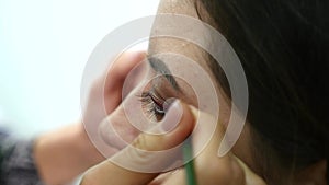 Make-up artist applying eyelash makeup to model`s eye. Close up view