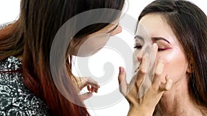 Make-up artist applying eyelash makeup to model`s eye. Close up view