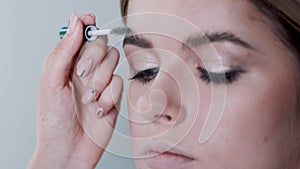 Make-up artist applying eyelash makeup to model`s eye. Close up view.