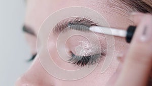 Make-up artist applying eyelash makeup to model`s eye. Close up view.