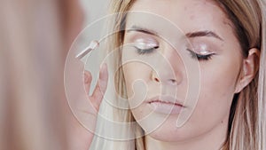 Make-up artist applying eyelash makeup to model`s eye. Close up view.