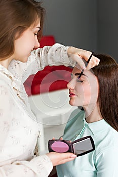 Make up artist applying make-up on girl face