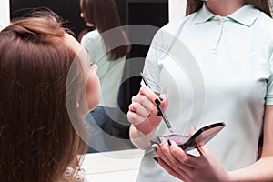 Make up artist applying make-up on girl face