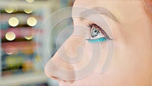 Make-up artist applying makeup to model`s eye. Close up view.