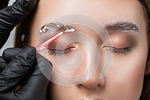 The make-up artist does Long-lasting styling of the eyebrows of the eyebrows and will color the eyebrows. Eyebrow lamination.