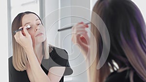 Make-up artist doing eyes makeup for her self