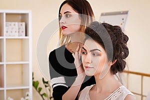 Make-up artist doing make-up girl in the salon, beauty concept