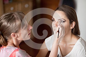 Make up artist doing makeup for model