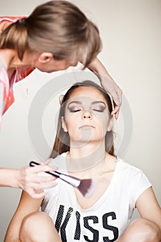 Make up artist doing makeup for model