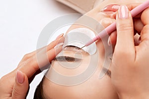 Make-up artist makes the procedure of lamination and dyeing of eyelashes to a beautiful woman in a beauty salon. Eyelash