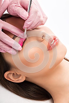 Make-up artist makes the procedure of lamination and dyeing of eyelashes to a beautiful woman in a beauty salon. Eyelash