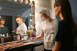 Make up artist taking brush while doing make-up