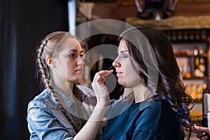 Make-up artist working with woman client