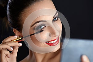 Make-up. Beautiful Woman Doing Makeup. Mascara Brush. Red Lips