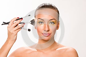 Make up. Brown sleek hair beautiful woman with fan brush close t