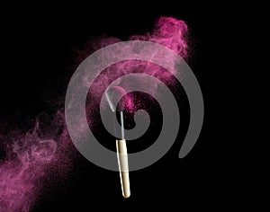 Make-up brush with pink powder explosion on black