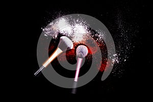 Make-up brush with white powder spilled glitter dust on black background. Makeup brush on new year`s Party with bright colors.