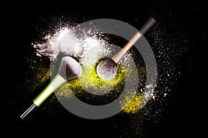 Make-up brush with white powder spilled glitter dust on black background. Makeup brush on new year`s Party with bright colors.