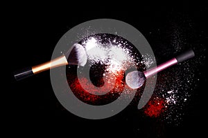 Make-up brush with white powder spilled glitter dust on black background. Makeup brush on new year`s Party with bright colors.