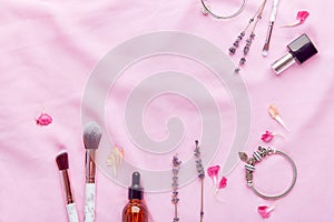Make up brushes, dropper bottle- serum elixirs, female accessories among lavender flat lay with copy space