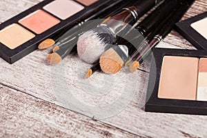 Make up brushes next to cosmetics products