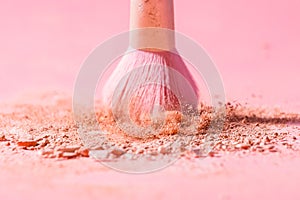 Make up brushes with powder splashes isolated on pink background