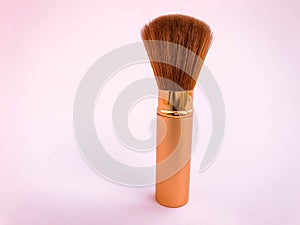 Make up brushes with powder splashes isolated on pink background