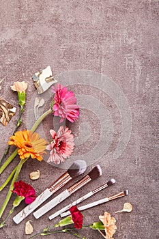 Make up brushes set among flowers with copy space. Make artist proffessional tools