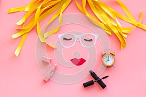 Make up concept with face model for visagiste work and alarm clock on pink background top view