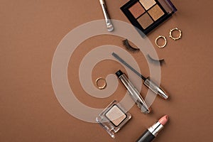 Make-up concept. Top view photo of eyeshadow palette makeup brush gold rings lipstick mascara and false eyelashes on isolated