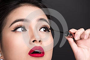 Make-up and cosmetics concept. Asian woman doing her makeup eyelashes black mascara.